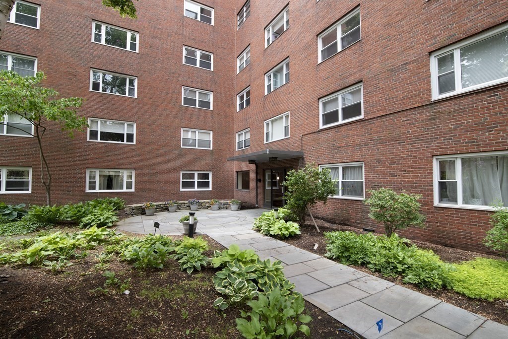 131 Sewall Avenue, Unit 37 Brookline, MA 02446 - Photo 26 of 27 a front view of a multi story residential apartment building with a yard and outdoor seating