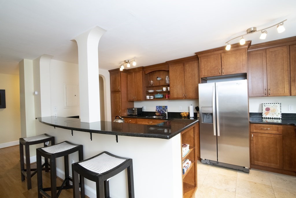 131 Sewall Avenue, Unit 37 Brookline, MA 02446 - Photo 6 of 27 a kitchen with kitchen island a counter top space cabinets and stainless steel appliances