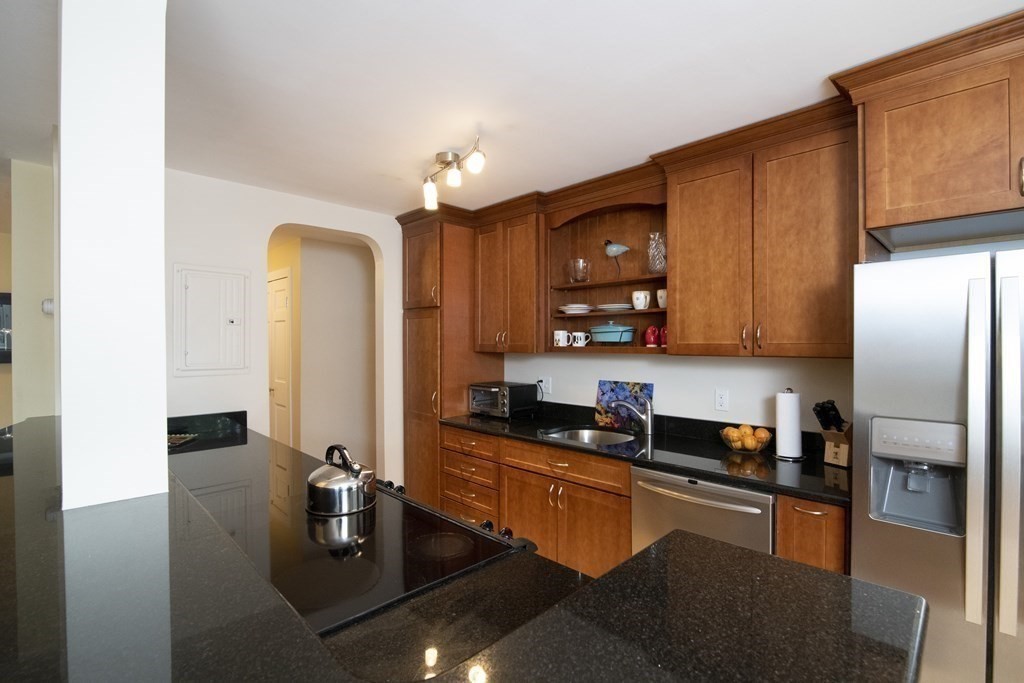 131 Sewall Avenue, Unit 37 Brookline, MA 02446 - Photo 8 of 27 a kitchen with stainless steel appliances granite countertop a sink refrigerator and cabinets