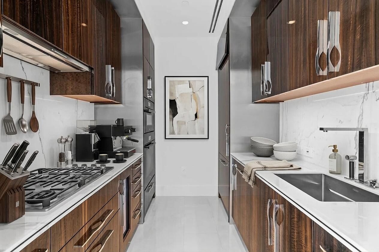 217 West 57th Street, Unit 43D Manhattan, NY 10019 - Photo 10 of 24 a kitchen with stainless steel appliances granite countertop a sink stove and cabinets