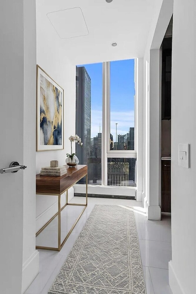 217 West 57th Street, Unit 43D Manhattan, NY 10019 - Photo 8 of 24 a living room with a large window and a rug