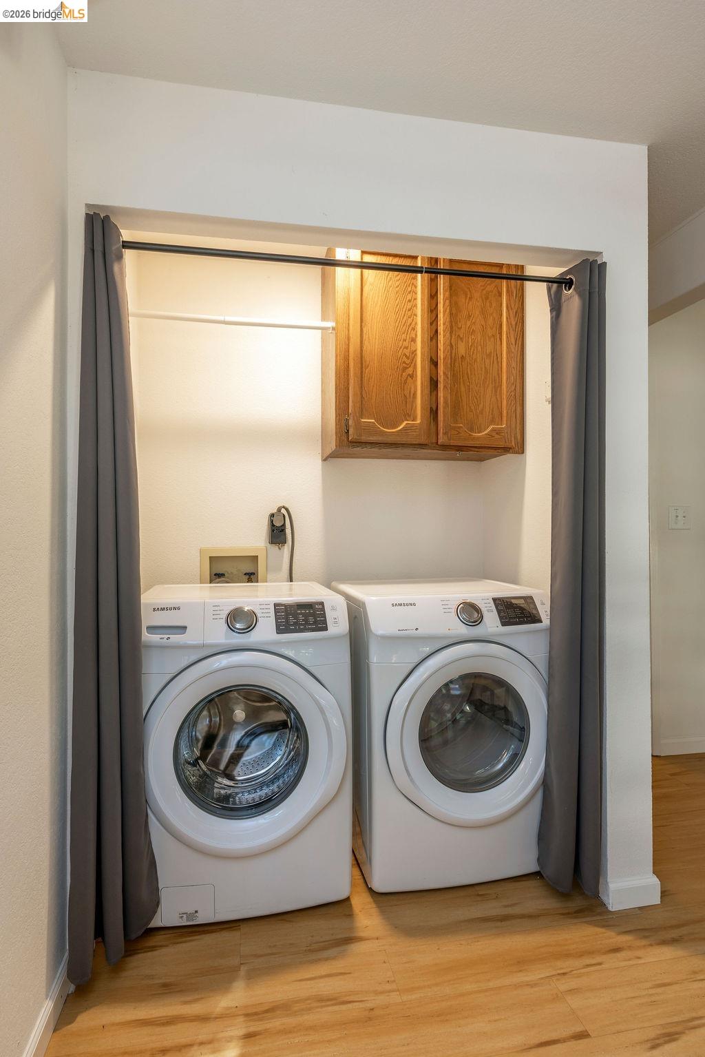 19266 Ferretti Road Groveland, CA 95321 - Photo 19 of 50 Laundry room featuring cabinet space, light wood finished floors, and independent washer and dryer