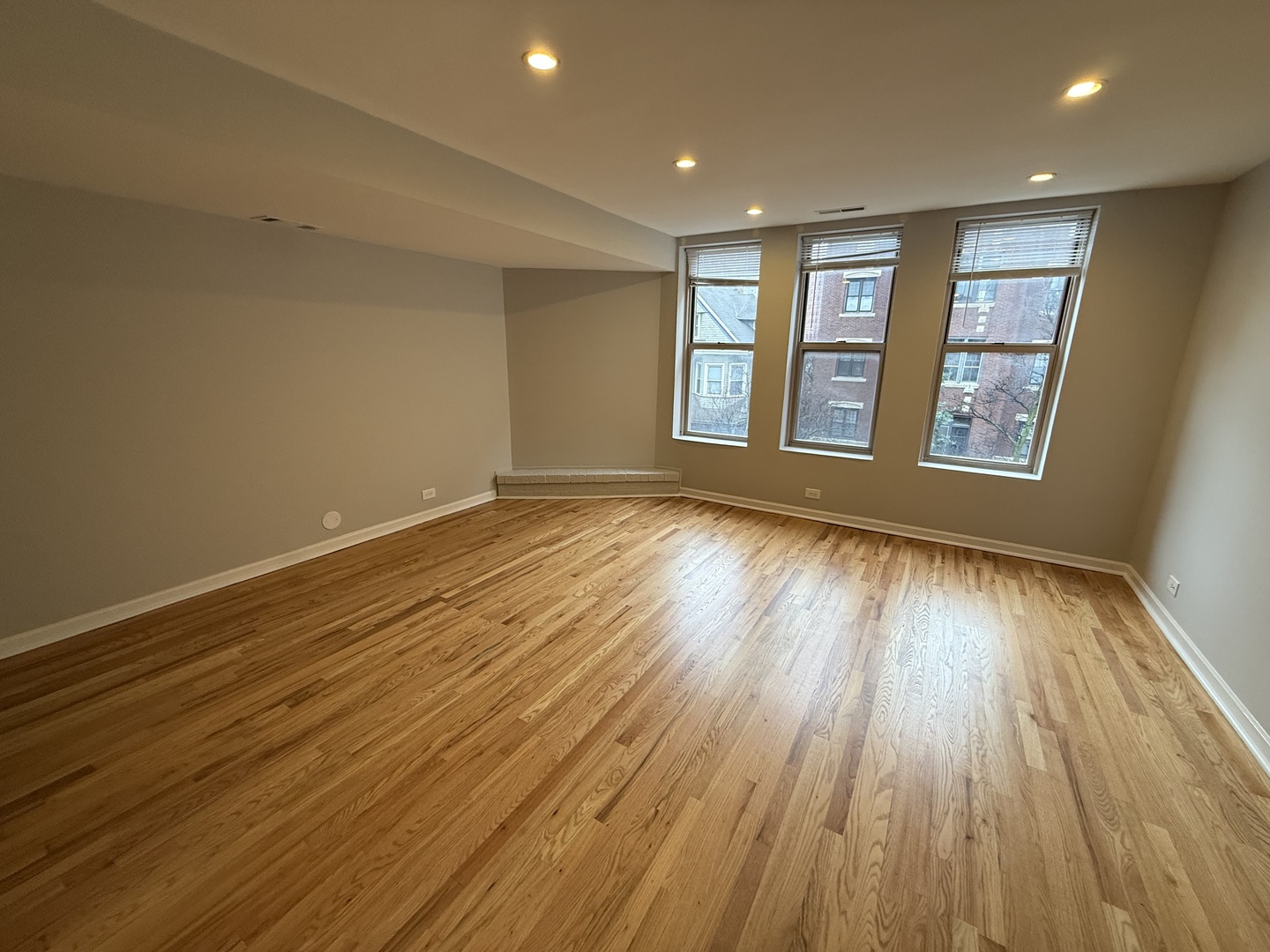 744 West Gordon Terrace, Unit 302 Chicago, IL 60613 - Photo 2 of 12 a view of an empty room with wooden floor and a window