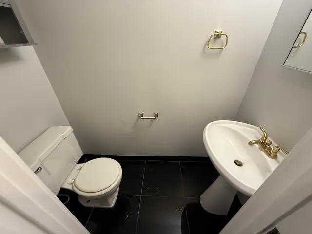 a white toilet sitting next to a bathroom sink