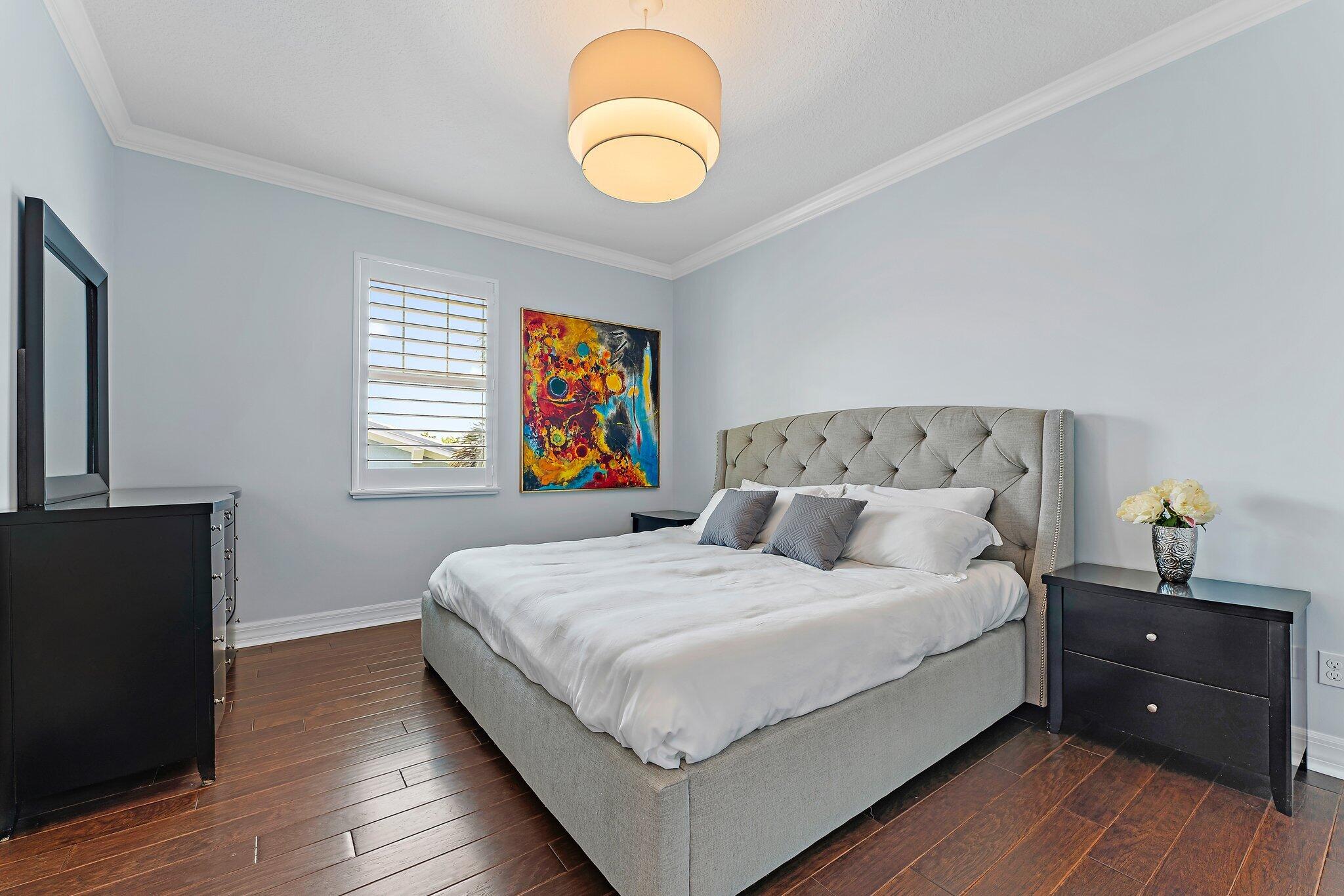 2835 East Mallory Boulevard Jupiter, FL 33458 - Photo 22 of 51 a bedroom with a bed and wooden floor