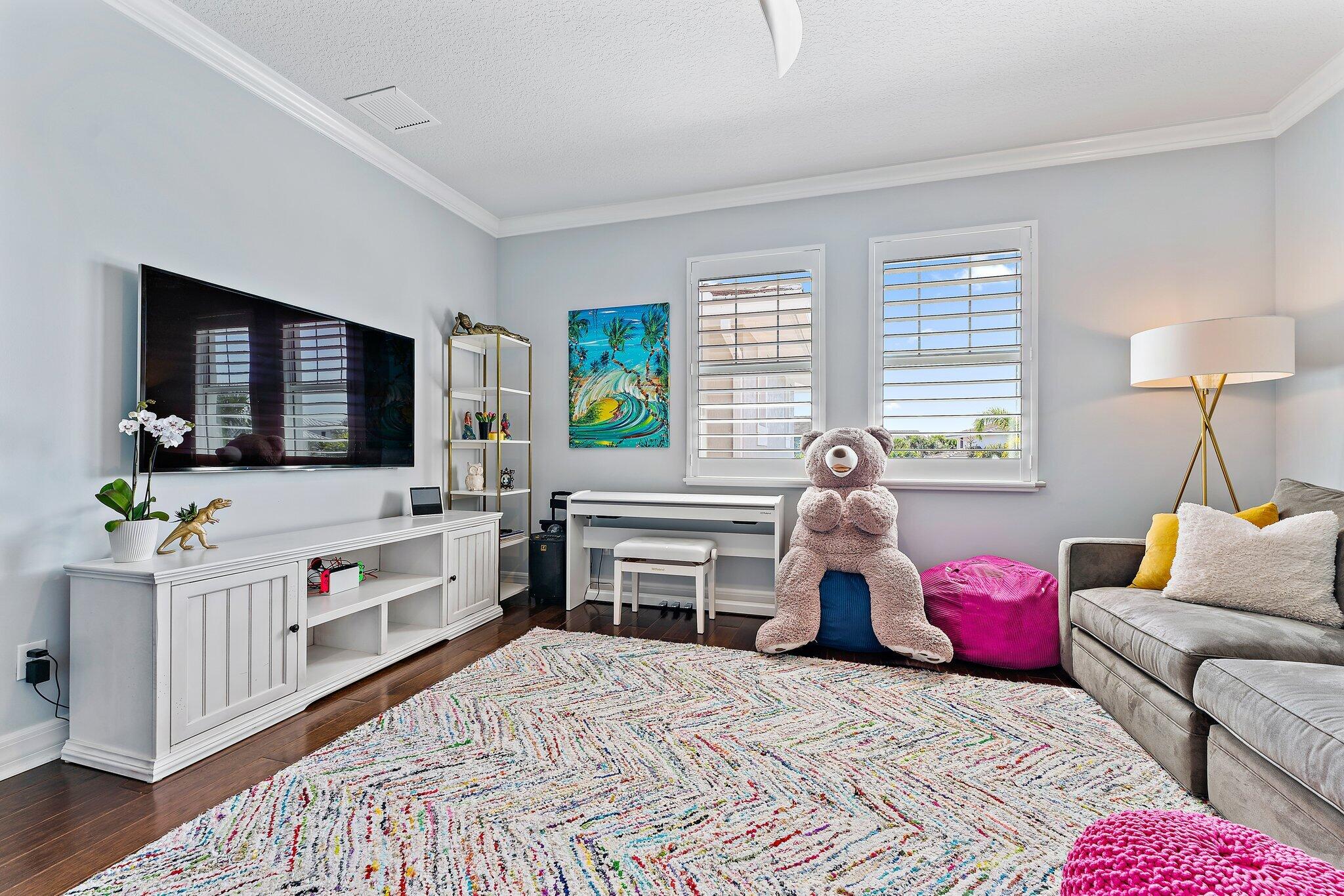 2835 East Mallory Boulevard Jupiter, FL 33458 - Photo 27 of 51 a bedroom with furniture and a flat screen tv