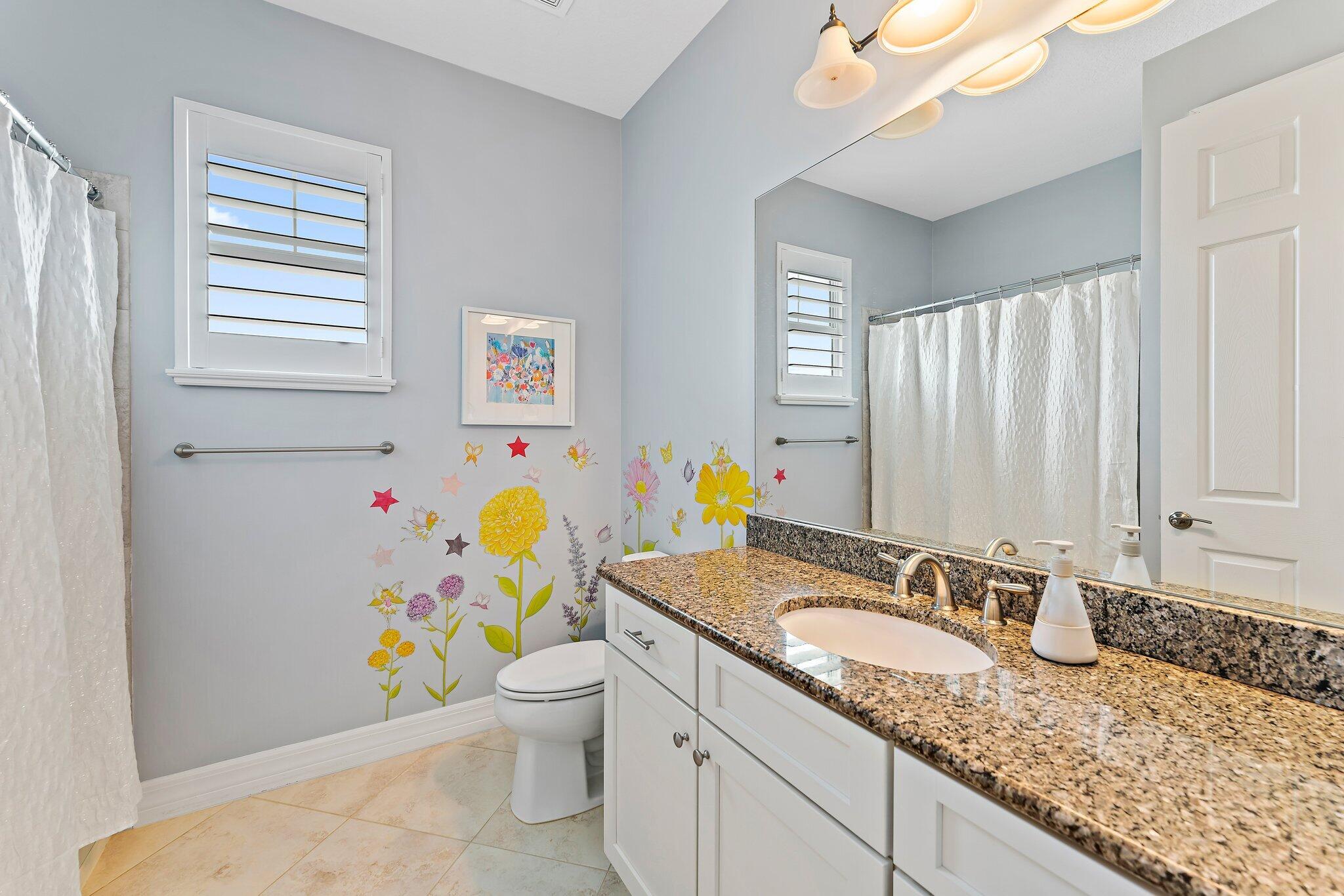 2835 East Mallory Boulevard Jupiter, FL 33458 - Photo 29 of 51 a bathroom with a granite countertop sink a toilet and a granite top & sink