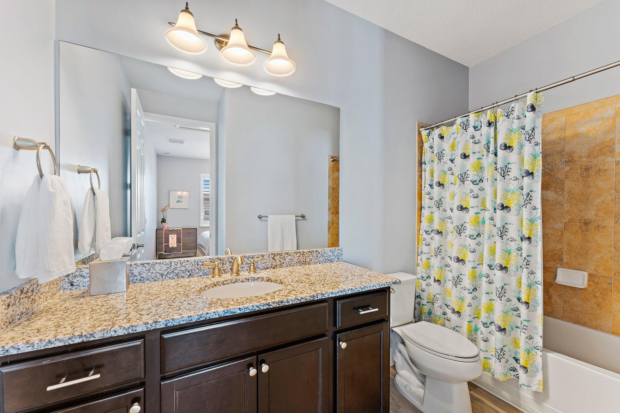 2835 East Mallory Boulevard Jupiter, FL 33458 - Photo 43 of 51 a bathroom with a granite countertop sink a toilet and a mirror