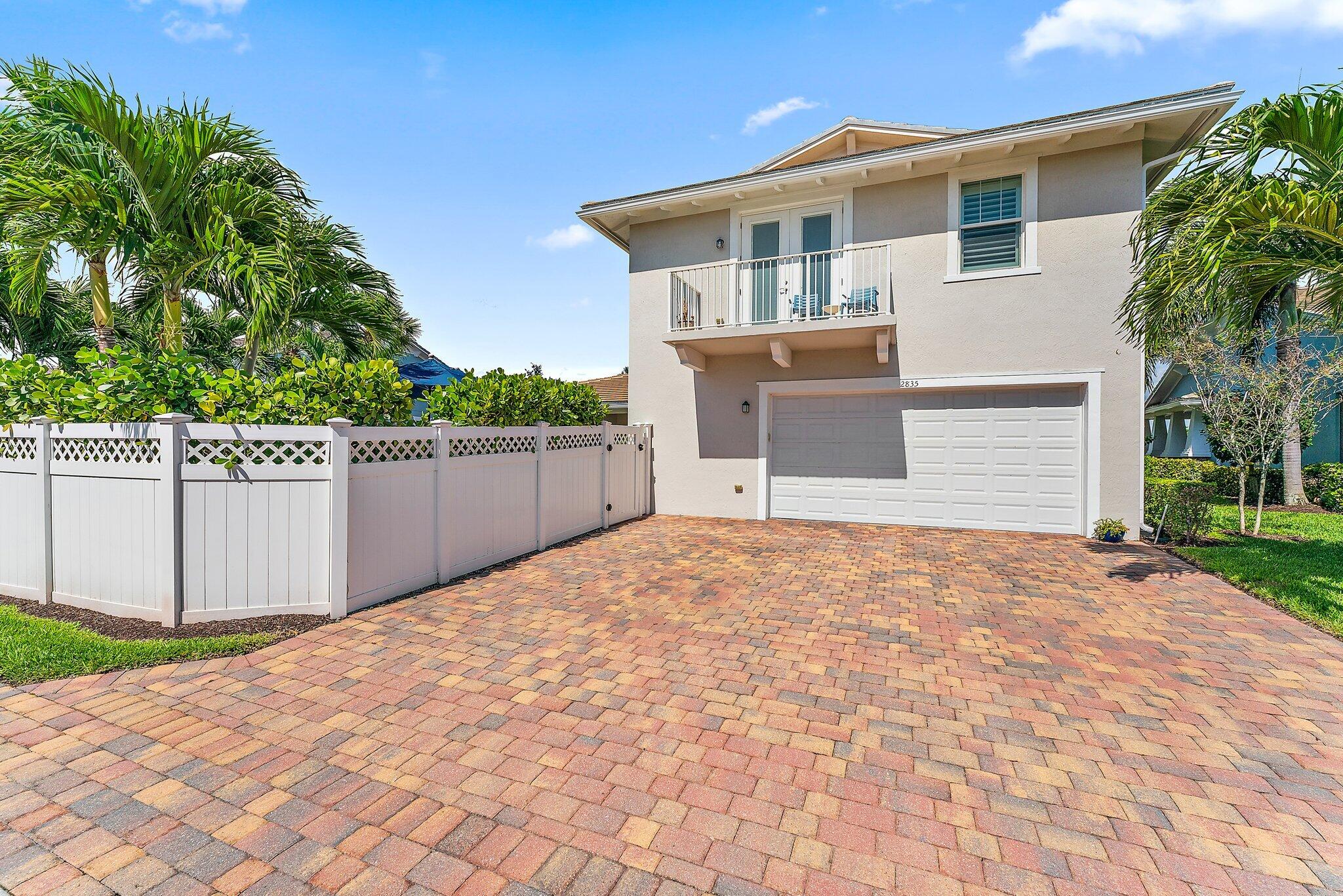 2835 East Mallory Boulevard Jupiter, FL 33458 - Photo 44 of 51 a front view of a house with a yard and garage