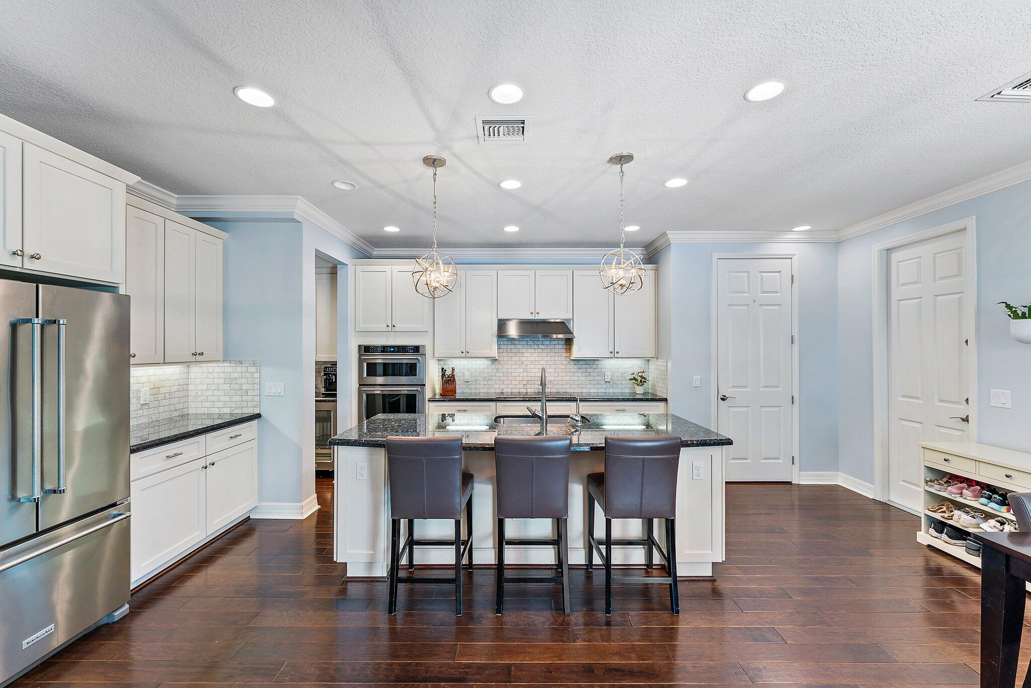 2835 East Mallory Boulevard Jupiter, FL 33458 - Photo 9 of 51 a kitchen with stainless steel appliances granite countertop a kitchen island hardwood floor and a sink