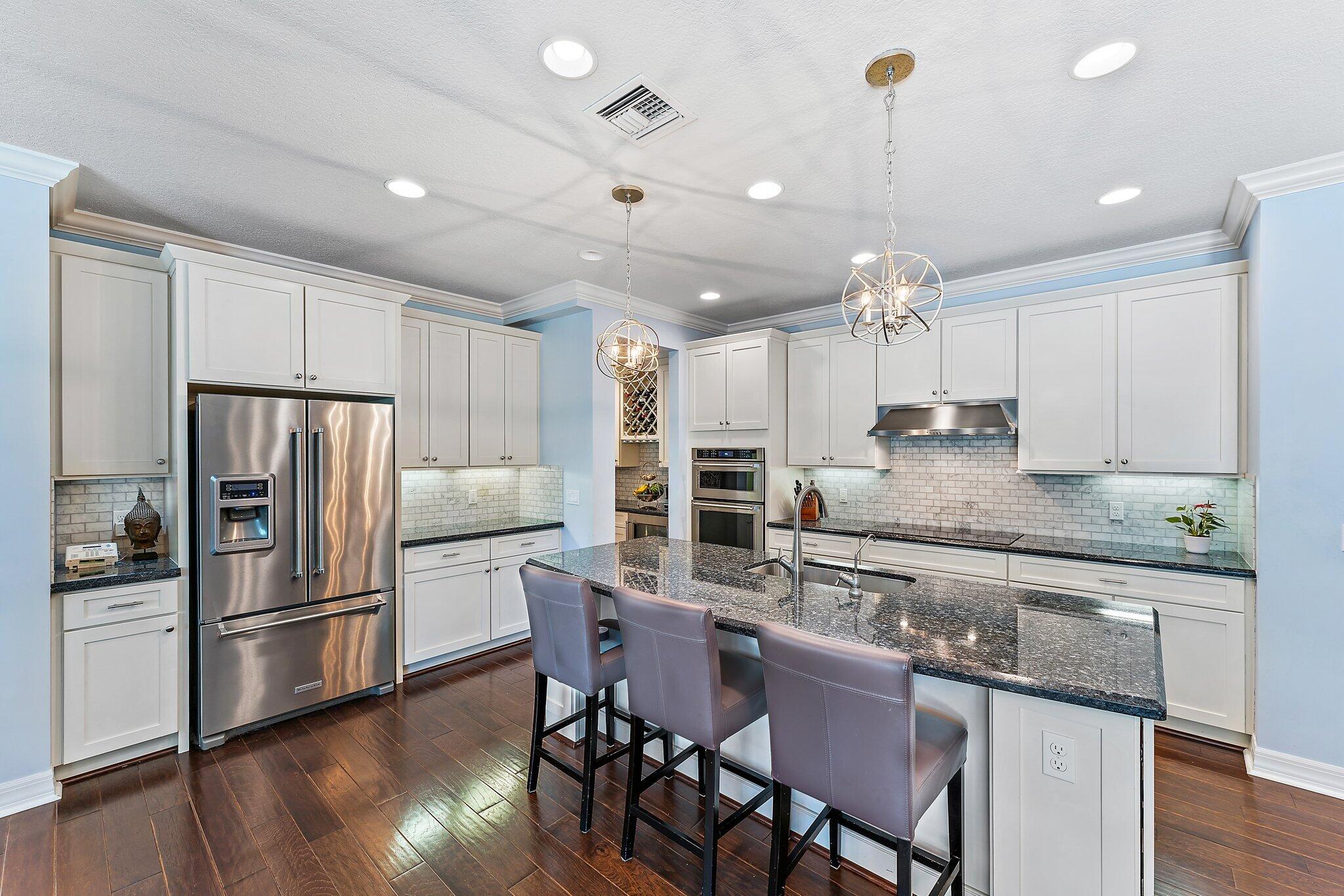 2835 East Mallory Boulevard Jupiter, FL 33458 - Photo 10 of 51 a kitchen with kitchen island granite countertop a sink and refrigerator