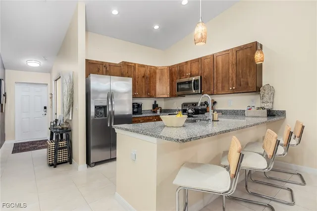 a kitchen with stainless steel appliances granite countertop a refrigerator and a stove top oven