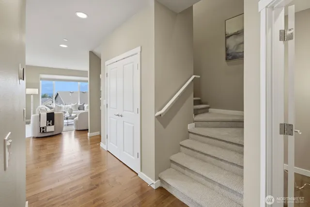 a kitchen with stainless steel appliances granite countertop a refrigerator a sink a stove a dining table and chairs