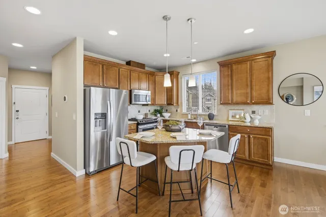 a kitchen with large windows and wooden cabinets