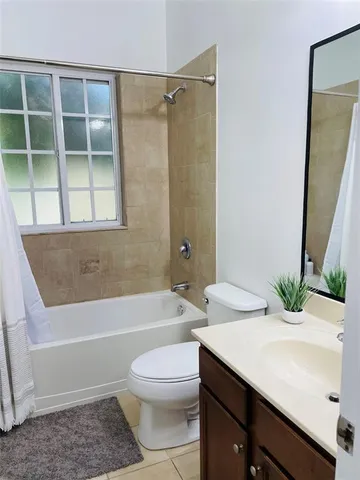 a bathroom with a sink a toilet a tub and shower