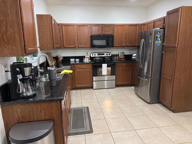 a kitchen with stainless steel appliances a refrigerator a stove a sink and a microwave