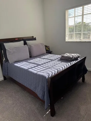 a bed sitting in a bedroom next to a window