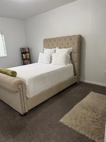 a bedroom with a bed and a night stand