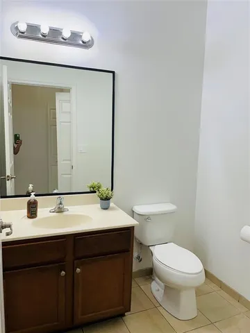 a bathroom with a sink vanity mirror and toilet