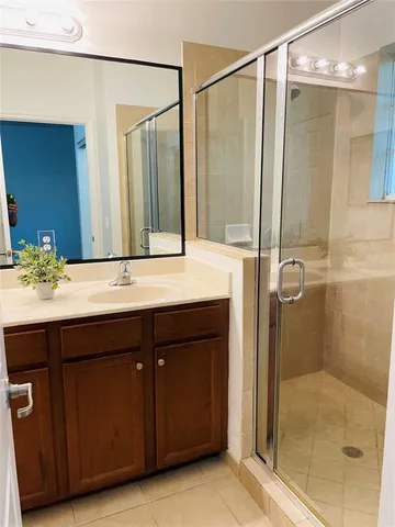 a bathroom with a double vanity sink mirror and shower