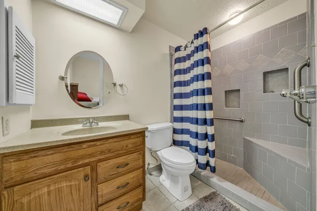 a bathroom with a sink a toilet and shower
