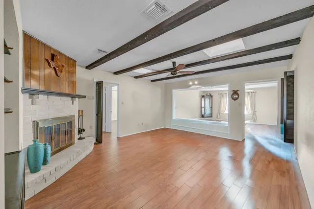 a view of empty room with wooden floor and fireplace