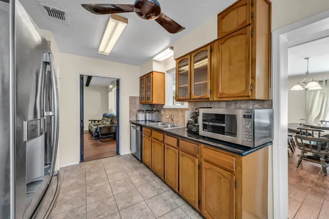 a kitchen with stainless steel appliances granite countertop a refrigerator a stove and a sink