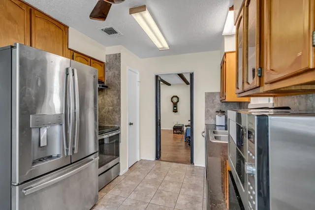 a view of a refrigerator and an entryway with kitchen view