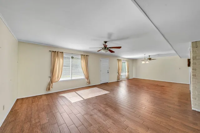wooden floor in an empty room with a window