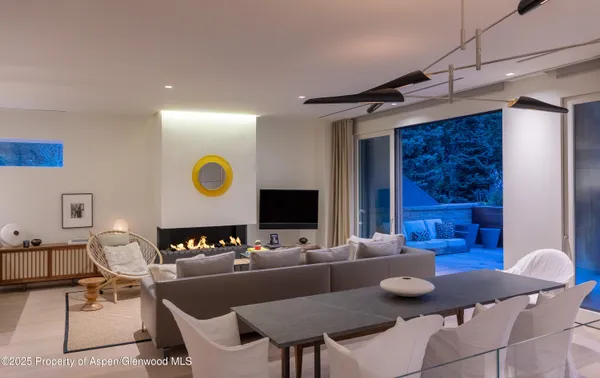 a living room with furniture kitchen view and a wooden floor