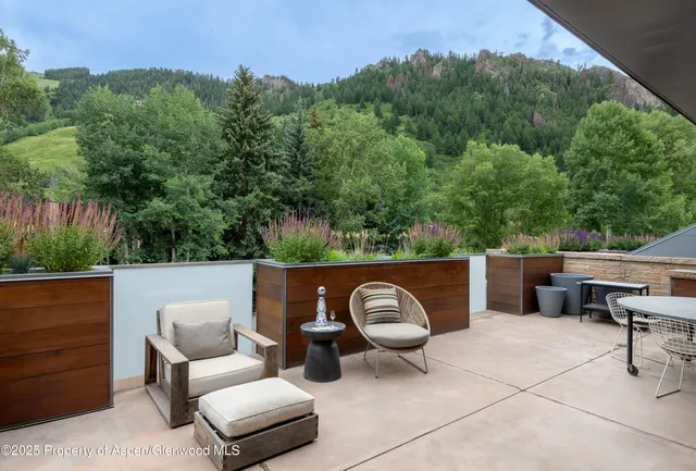 a view of balcony with outdoor seating and a lots of bushes