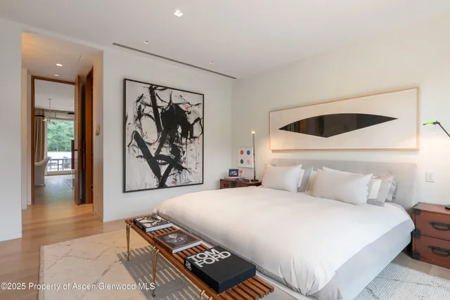 a bedroom with a bed and a painting on the wall