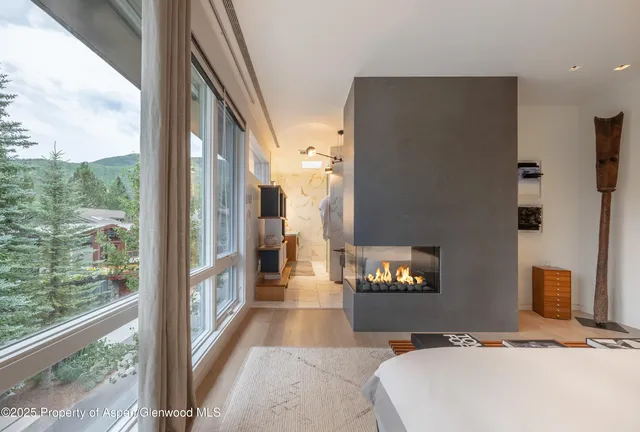 a bedroom with a bed and a large window with outer view