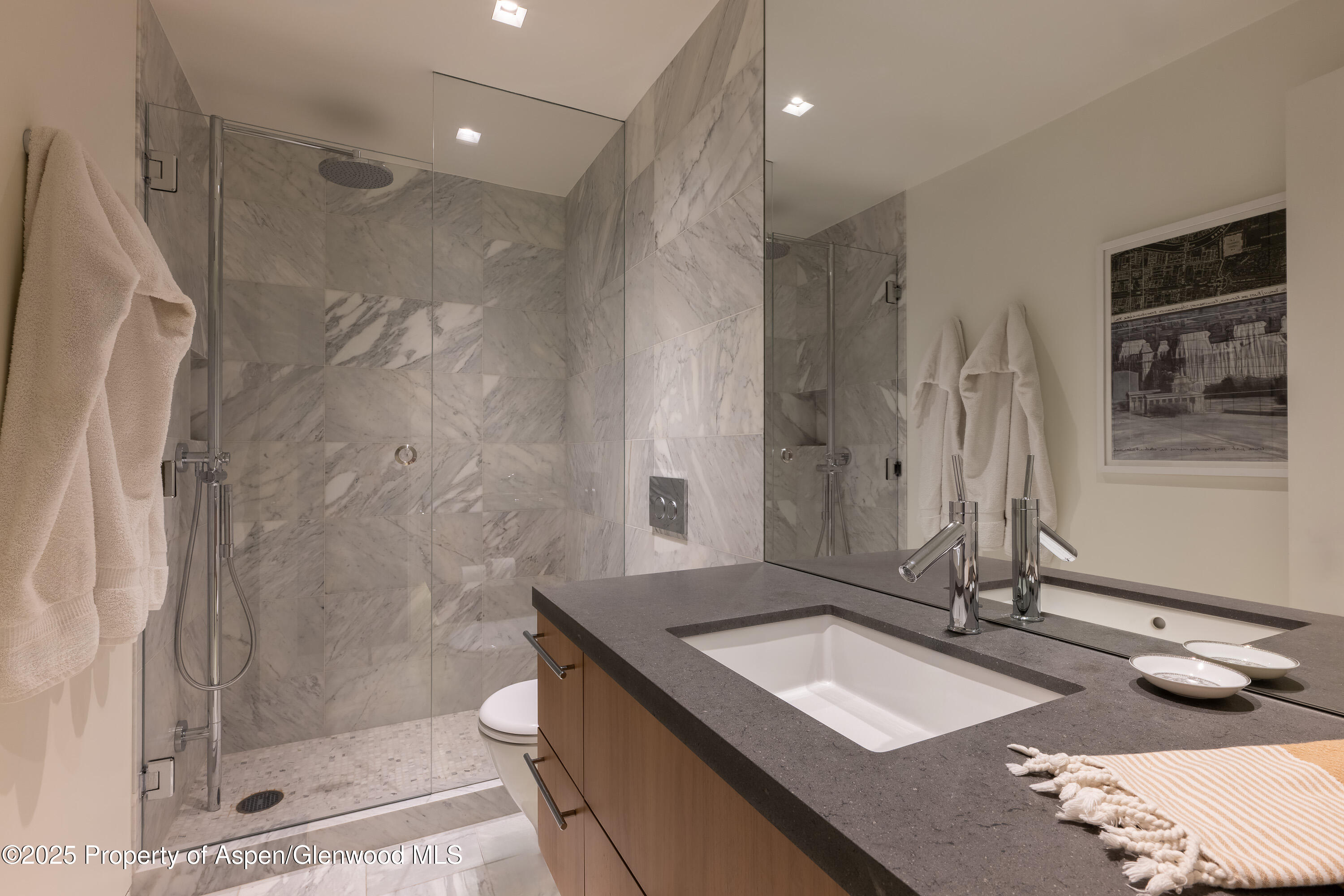 100 East Cooper Avenue, Unit 11 Aspen, CO 81611 - Photo 36 of 44 a bathroom with a granite countertop sink a toilet a large mirror and shower
