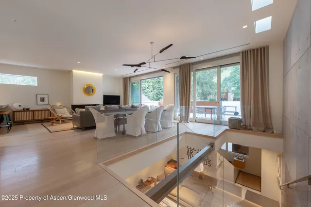 a living room with furniture large window and wooden floor