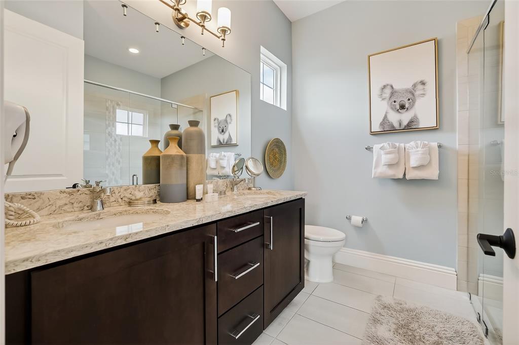 580 Muirfield Loop Reunion, FL 34747 - Photo 13 of 55 a bathroom with a granite countertop sink a toilet and a mirror