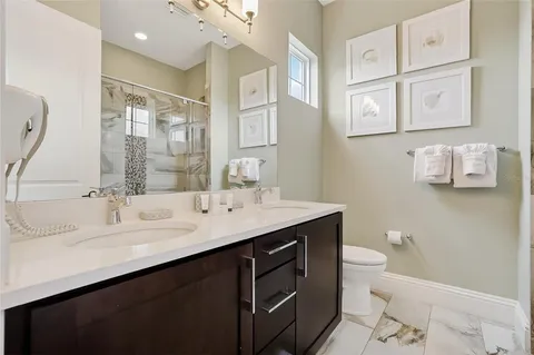 a bathroom with a granite countertop sink a toilet and a mirror