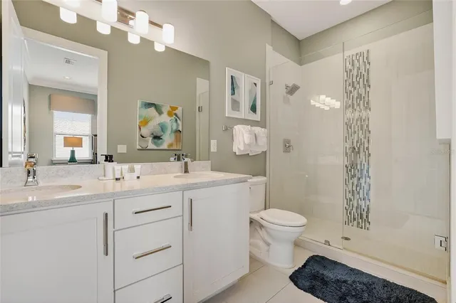 a bedroom with a bed a chandelier and a large window