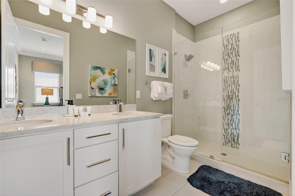 580 Muirfield Loop Reunion, FL 34747 - Photo 32 of 55 a spacious bathroom with a sink a toilet a shower and a mirror