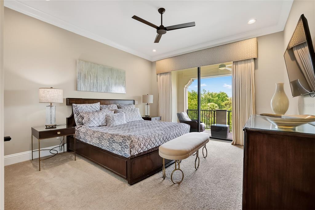 580 Muirfield Loop Reunion, FL 34747 - Photo 34 of 55 a bedroom with a bed a chandelier and a large window