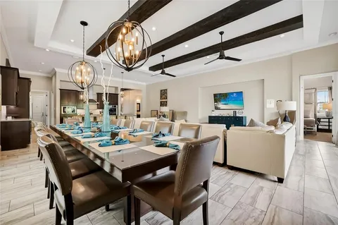 a dining room with wooden floor a chandelier a wooden table and chairs