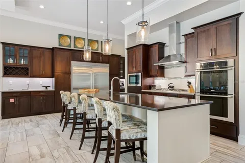 a kitchen with stainless steel appliances kitchen island granite countertop a refrigerator and a stove top oven