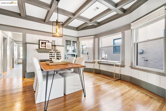 a dining hall with stainless steel appliances granite countertop a stove and a dining table with wooden floor