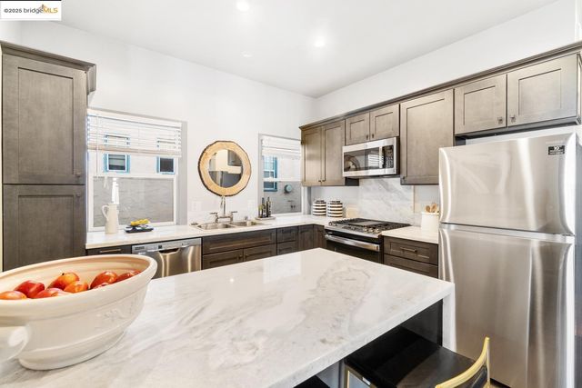 a kitchen with kitchen island a refrigerator sink and stove