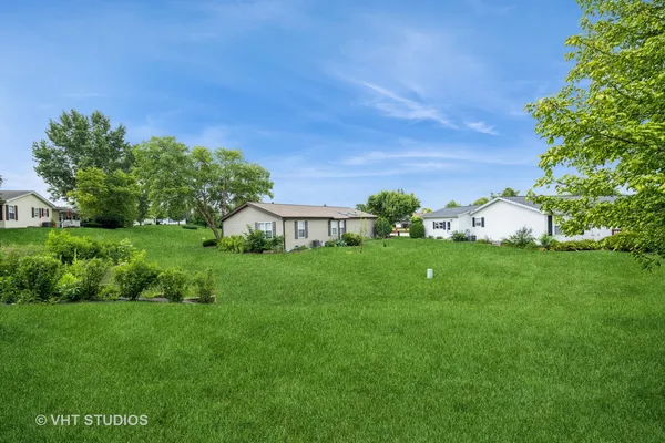a view of a garden with house in the background