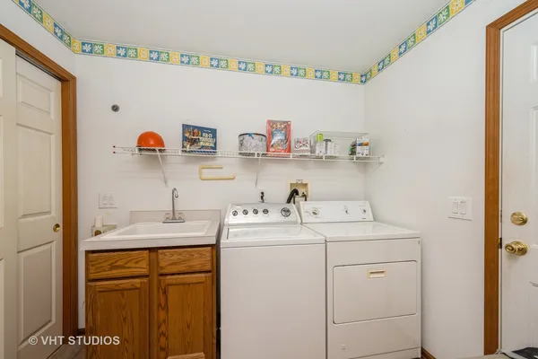 a utility room with sink dryer and washer