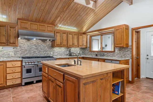 an aerial view of a house with a yard and lake view