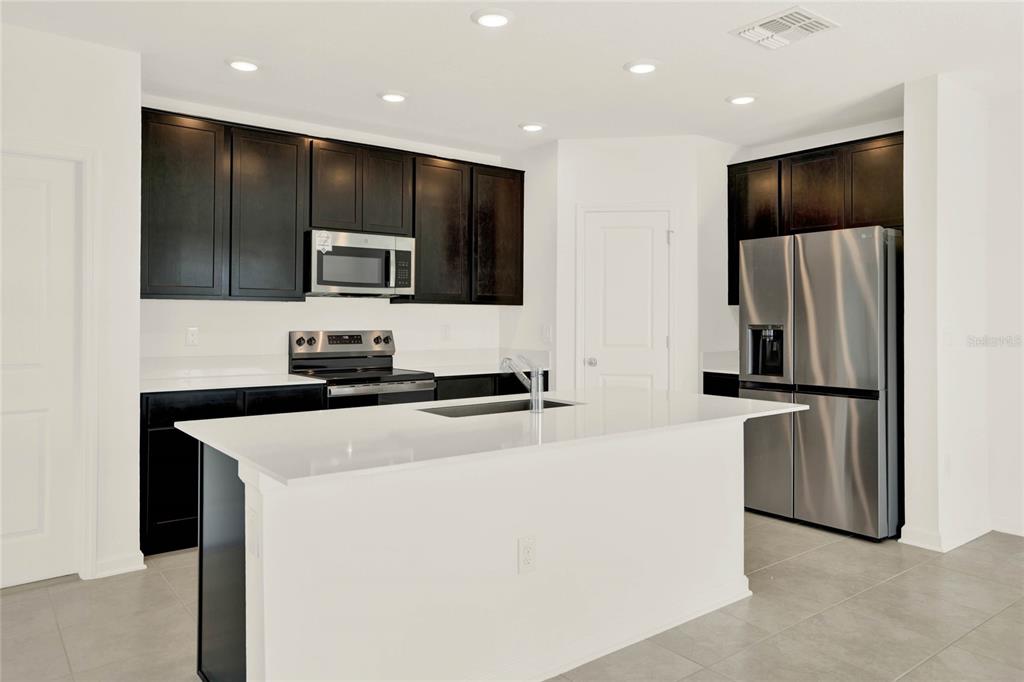 517 Bell Prairie Circle Lake Wales, FL 33859 - Photo 6 of 42 a kitchen with stainless steel appliances a refrigerator and a stove top oven