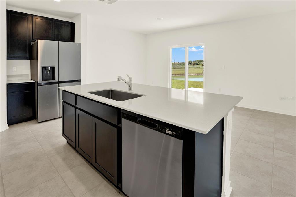 517 Bell Prairie Circle Lake Wales, FL 33859 - Photo 8 of 42 a kitchen with a sink a refrigerator and a stove top oven