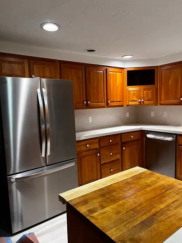 a kitchen with stainless steel appliances granite countertop a refrigerator and a stove top oven
